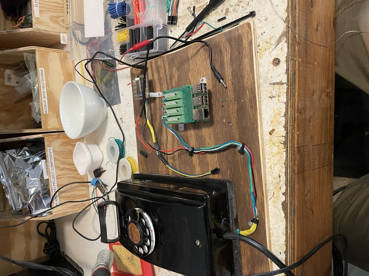 The finished rotary phone mounted on a stained plywood board and wired to a Raspberry Pi